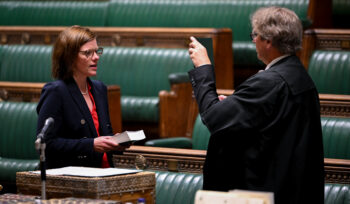 Alex Baker (l) being sworn in as an MP